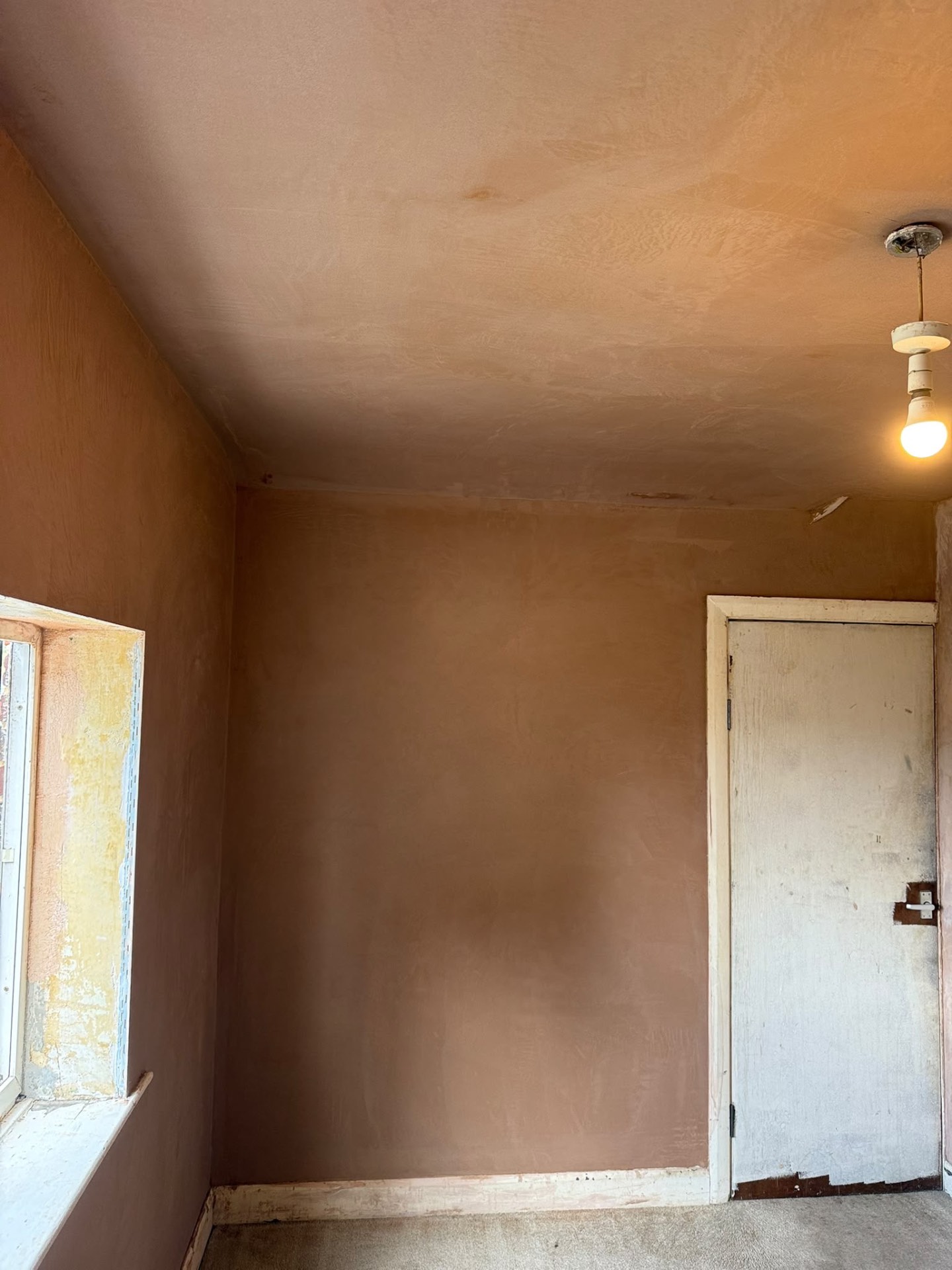 Bedroom walls and ceiling replastered around a window and door