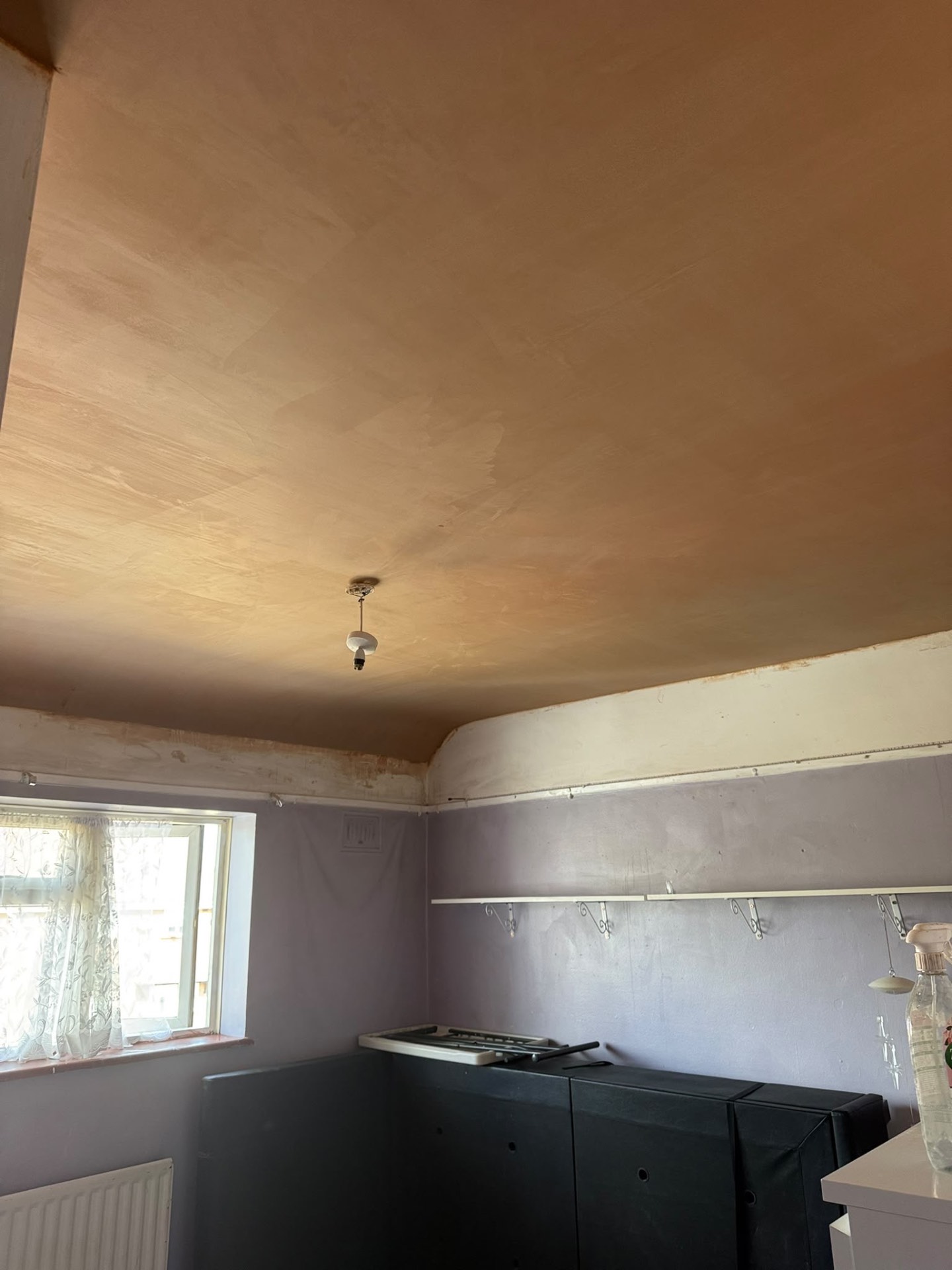 Newly skimmed ceiling with a smooth curved edge above the walls